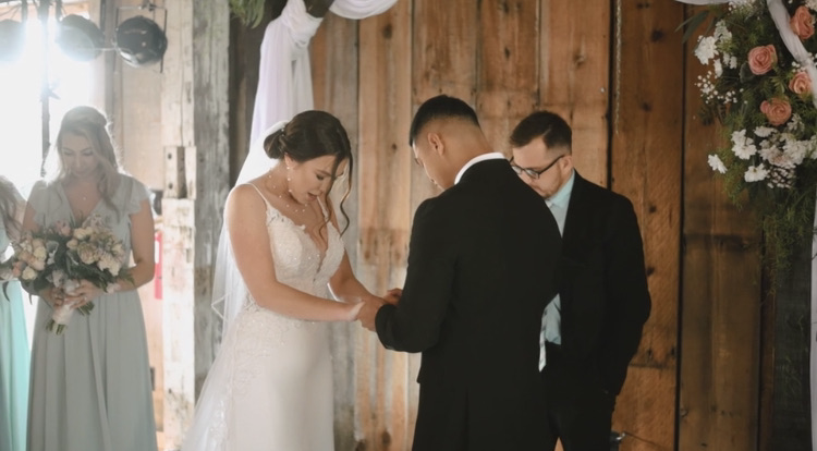 A couple exchanging rings during a barn wedding ceremony led by Eric